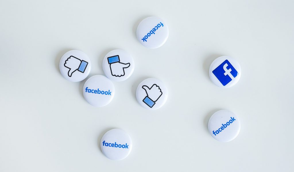 Facebook badges with like and dislike icons scattered on a pale background