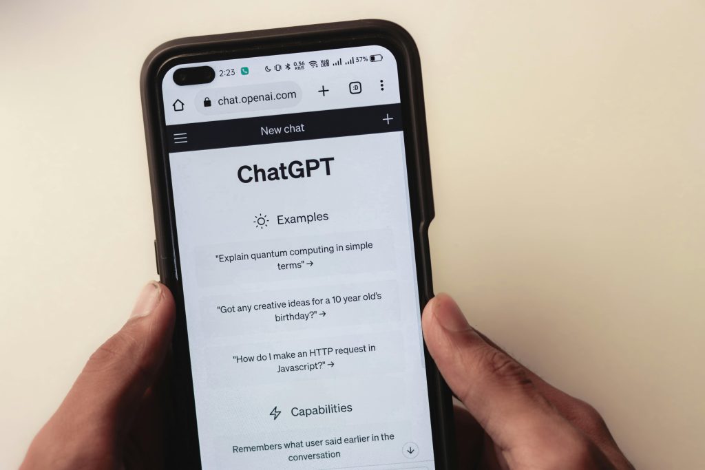 Hands holding a smartphone with the ChatGPT app open on screen