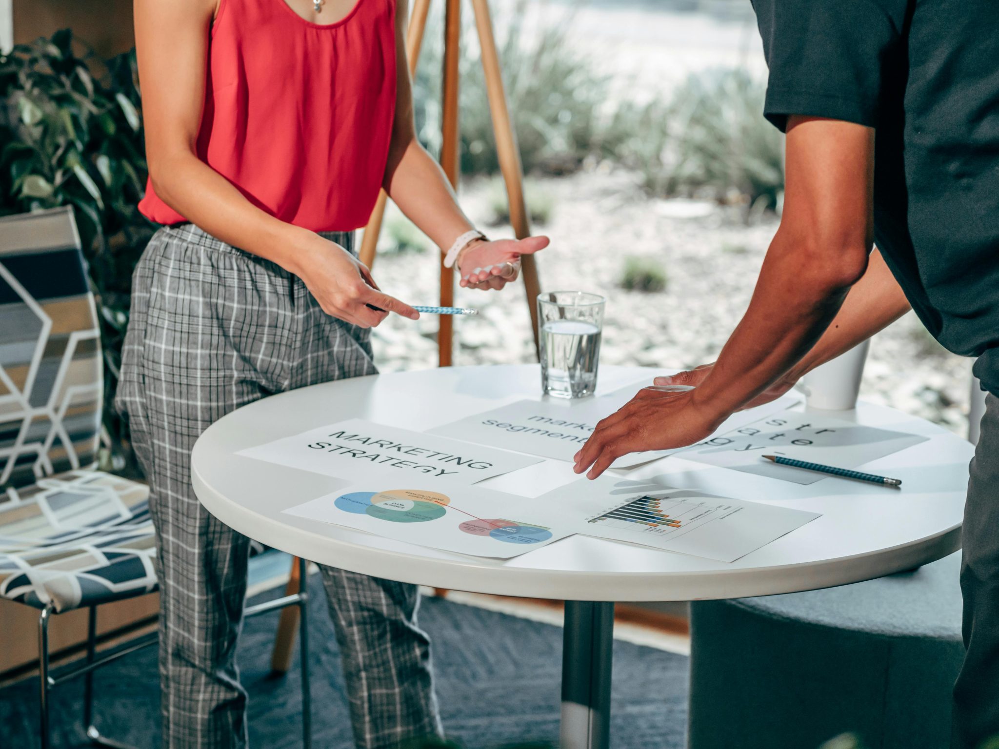A team meeting around an outdoor table with laptops and notebooks