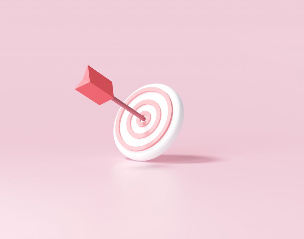 Dart hitting the centre of a target on a pink background